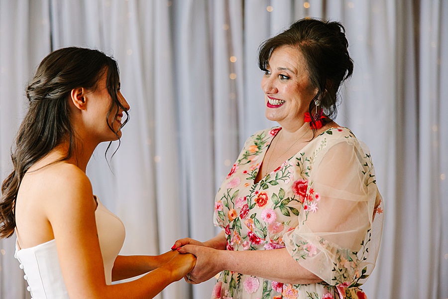 mom and daughter holding hands on wedding day at venue at the bluffs