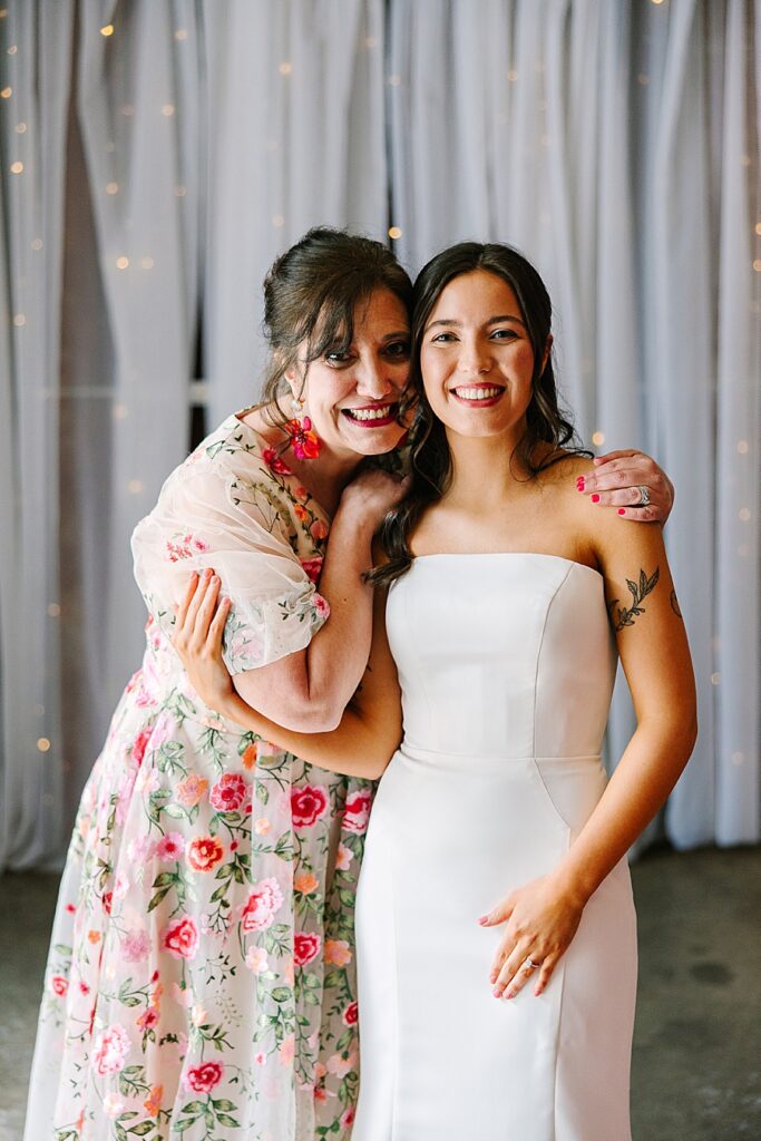 mom and daughter embracing on wedding day at venue at the bluffs
