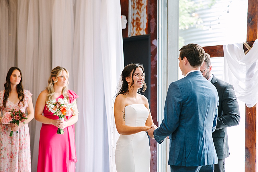 bride and groom holding hands at alter during wedding at venue at the bluffs
