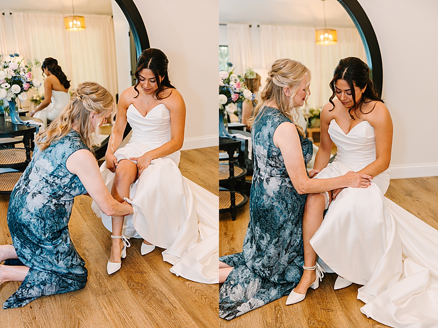 mom of the groom giving bride her something borrowed and praying with her before wedding day