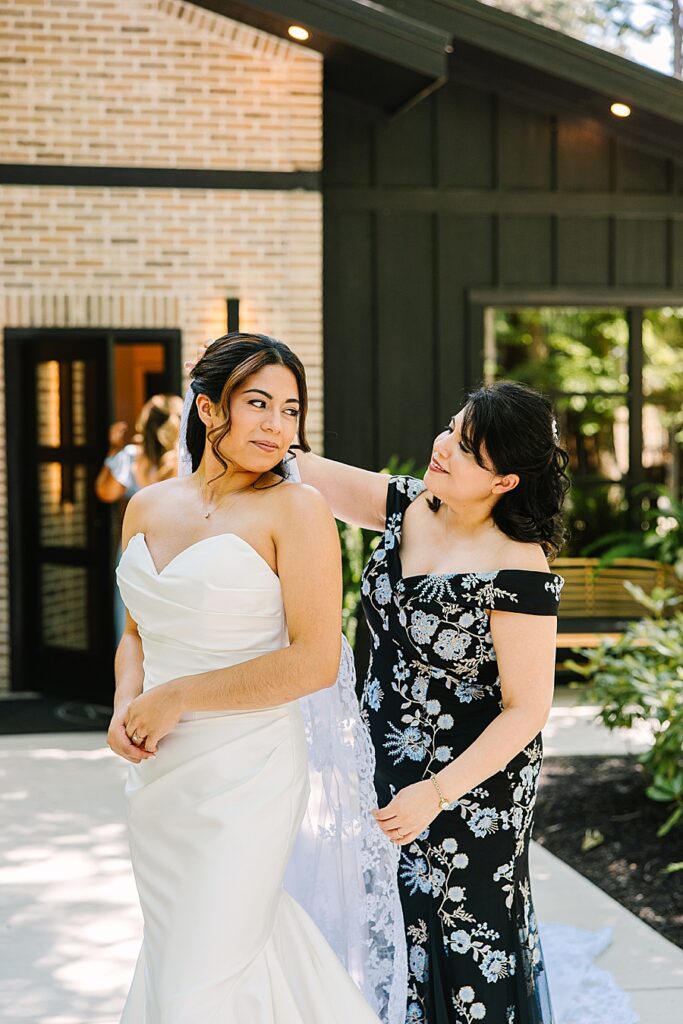mother of bride putting in bride's veil outside of the bridal house at Nichols Heir Glass House