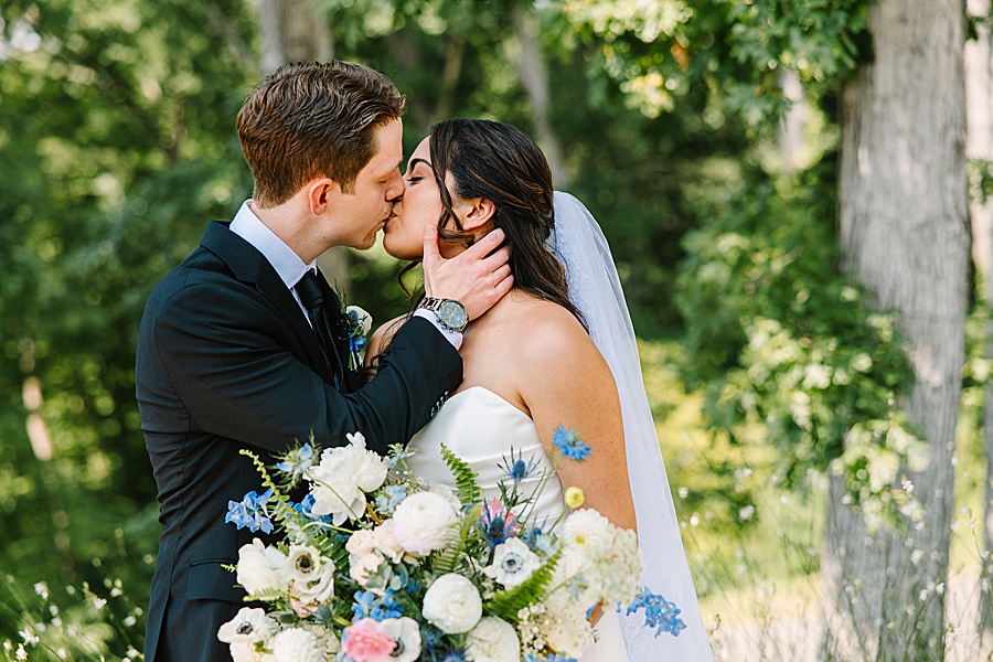 bride and groom kissing with bouquet of lush floral design by Valley Flowers in Chattanooga TN