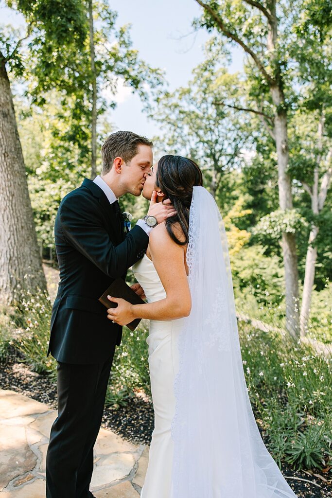 Bride and groom kissing in secret garden at Nichols Heir