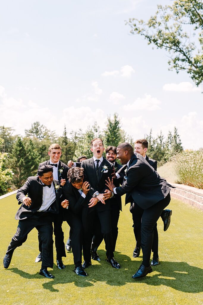 Groom and groomsmen having fun on wedding day