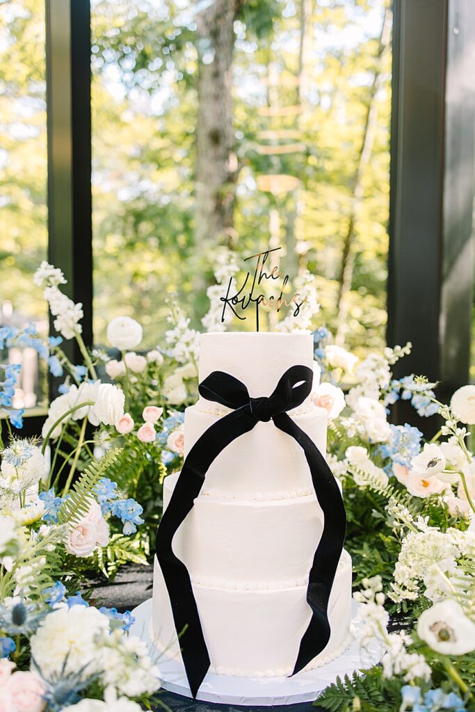4 tier white wedding cake surrounded by lush florals at Nichols Heir
